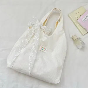 Cream white polka dot canvas tote bag with elegant white lace bow detail for daily use.