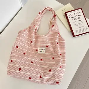 Red and white striped tote bag with cute heart embroidery, detailed view of fabric.