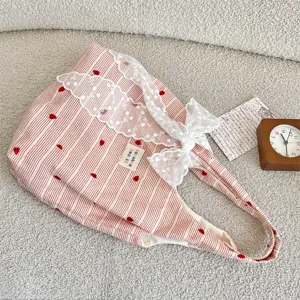 Pink striped tote bag with red hearts, cute white lace trim and bow. Detail view for students.