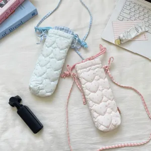 Korean style quilted heart camera bag with plaid drawstring and strap, detailed lifestyle view.