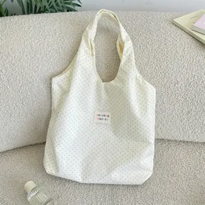 Detailed close-up view of cream white polka dot canvas tote bag, casual daily casual style.