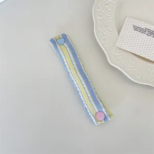 Macaron striped cable organizer strap with cute heart and round snap buttons for tidy desks.