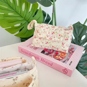 Cremeweißes Kosmetiktäschchen aus Canvas mit Blumenmuster und rosa Herz-Druckknopf.
