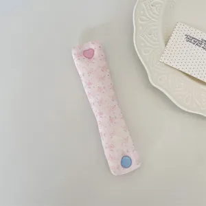 Pink floral cord organizer strap with cute heart and round buttons for earphone cable storage.