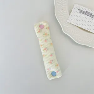 Floral pattern cable organizer strap with cute heart snap for neat earphone storage.