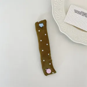 Close-up detail view of a cute fabric cable organizer with colorful heart and round buttons.