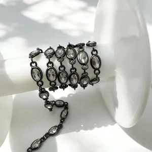 Detailansicht der schwarzen Metallkette mit funkelnden ovalen Zirkoniasteinen für DIY Schmuck.
