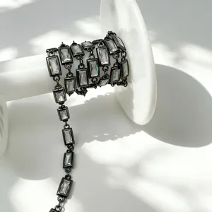 Gros plan d'une chaîne en métal noir plaqué avec des zircons carrés blancs pour bijoux faits maison.