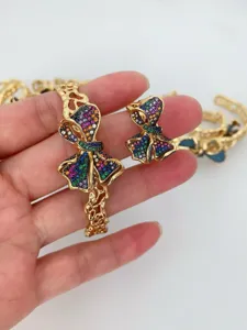 Nahaufnahme des bunten Zirkon Schleifen Schmucksets mit feinen goldenen Hohlringen.