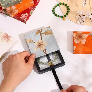 Boîte cadeau de bijoux à tiroir floral Guofeng avec présentoir transparent suspendu et bracelet.