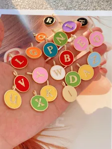 Nahaufnahme von bunten Emaillierten Buchstaben Anhängern mit glitzernden Zirkonia Steinen.