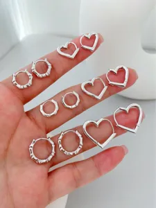 Detailed view of silver bamboo hoop and heart huggie earrings set, elegant daily jewelry.