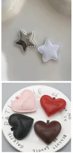 Vista dettagliata di accessori DIY in pelle a stella e cuore per scatola regalo e bouquet.