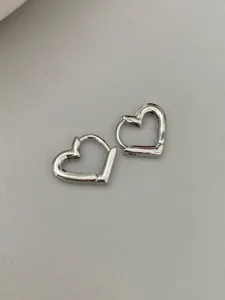 Detailed shot of silver heart hoop earrings, minimal and elegant design for daily wear.