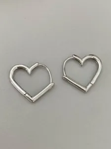 Silver heart shaped hoop earrings detail, minimalist chic daily wear jewelry accessory.