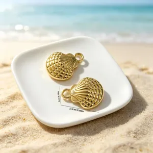 Detailed close-up of golden alloy shell charms with size dimensions on white plate