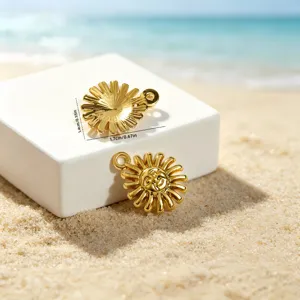 Detailed view of gold sun pendants on beach sand with dimensions 1.4cm and 1.7cm