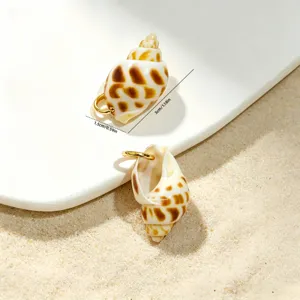 Close-up of ocean style seashell charms with dimensions 3x1.5cm on beach sand.