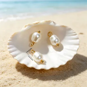Detail view of ocean style baroque pearl charms inside a seashell with dimensions