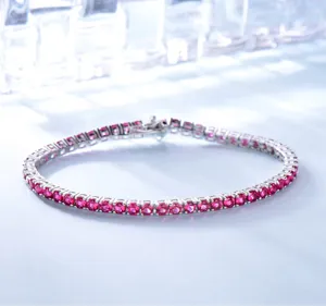 Detailaufnahme des silbernen Tennisarmbands mit funkelnden roten Edelstein-Akzenten.