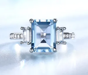 Detaillierter Ring aus Sterlingsilber mit blauem Topas im Smaragdschliff und Steinen.