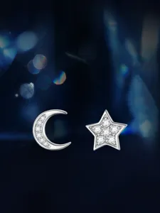 Nahaufnahme Detail von silbernen Stern und Mond Ohrringen mit glitzernden Moissanit Steinen.