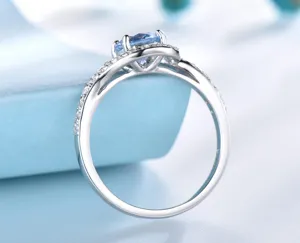 Detaillierte Nahaufnahme eines Sterlingsilberrings mit blauem Zirkonia und feinen Zirkoniasteinen.