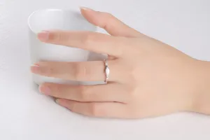 Silberring mit weißem Opal und funkelnden Zirkoniasteinen in Nahaufnahme.