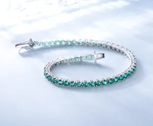 Detailaufnahme eines S925 Silber Tennisarmbands mit funkelnden grünen Steinen.