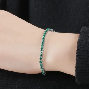 Detailaufnahme eines Sterling Silber Tennisarmbands mit grünen Edelsteinen, eleganter Schmuck.