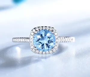 Detaillierte Nahaufnahme eines funkelnden Silberrings mit blauem Edelstein und Zirkonias.