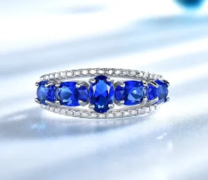 Detailansicht des Sterlingsilberrings mit ovalen blauen Saphiren und funkelnden Steinen.