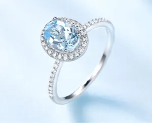 Nahaufnahme eines eleganten S925 Silber Rings mit hellblauem Topas und funkelnden Zirkonia.