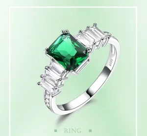 Nahaufnahme des Smaragdschliff grünen Edelsteinrings mit eleganten Baguette-Seitensteinen.