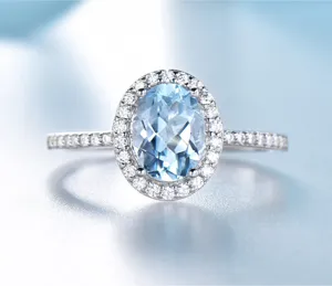 Detaillierte Nahaufnahme des ovalen hellblauen Topas Silber Rings mit funkelnden Steinen.