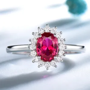 Nahaufnahme des atemberaubenden ovalen roten Edelsteinrings mit funkelndem Kristall-Blumenkranz.