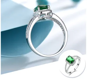 Erhöhter S925 Sterlingsilber Ring mit rechteckigem grünen Edelstein und glitzernden Zirkoniasteinen.