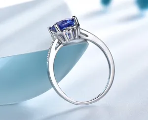 Zilveren blauwe edelsteen ring detail close-up met elegante klauwzetting en pavé stenen.