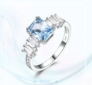 Vista detallada del anillo de plata con piedra preciosa azul claro y circonitas brillantes.