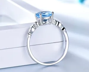 Nahaufnahme Detail eines Silberrings mit funkelndem blauen Edelstein und feinen Seitensteinen.