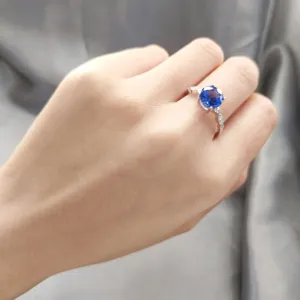 Detailansicht eines silbernen Rings mit blauem Zirkonstein und funkelndem Edelstein Design.