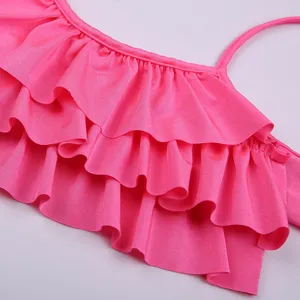 Pink children swimsuit detail, cute ruffled bikini top, vibrant swimwear for girls swimming.