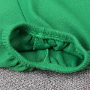 Détail élastique de costume de Noël vert, manchette en tissu doux et coutures fines pour enfants.