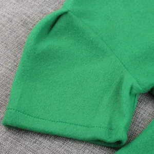 Gros plan sur la manche de costume verte en tissu feutré doux, idéale pour spectacle d'enfants.