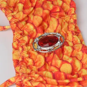 Kids mermaid bikini swimwear with rhinestone brooch detail, orange scale pattern swimsuit.
