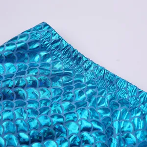 Dettaglio tessuto costumino sirena bambina con motivo squame di pesce blu lucido e vita.