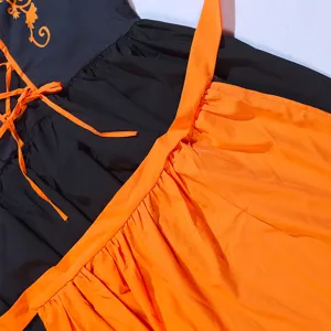 Nahaufnahme Detail des Oktoberfest bayrischen Kleides, schwarz-oranger Stoff, Schnürung.