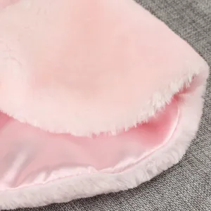 Détail de tissu de cape en peluche rose avec fausse fourrure douce et doublure satinée.