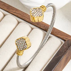 Twisted cable cuff bracelet with rhinestone clover ends, stylish metal jewelry for women.