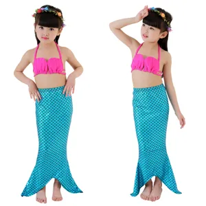 Girls mermaid swimsuit set detail featuring pink shell bikini top and sparkly blue tail skirt.